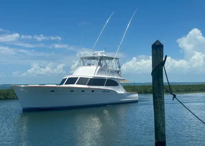 A sportfishing yacht passing a dock piling in the Florida Keys near mangroves